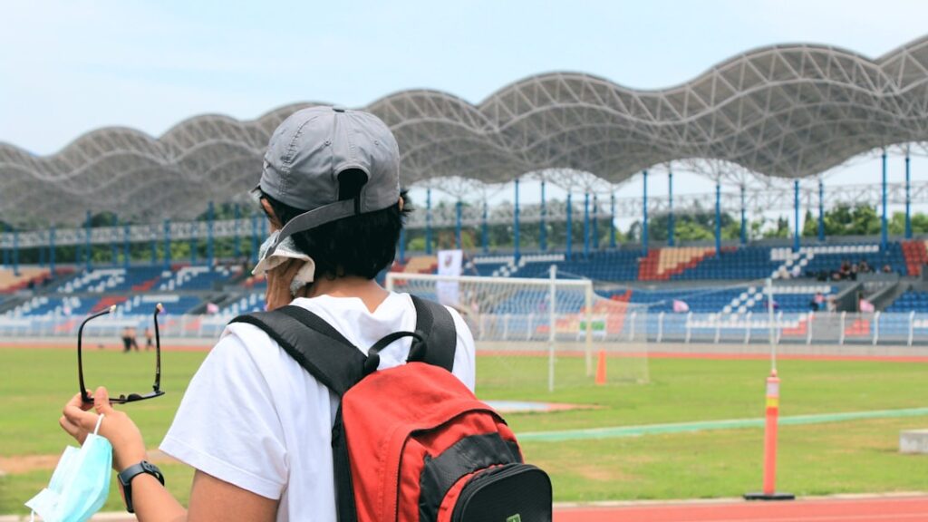 Sports management professional using data analytics software at a live sporting event