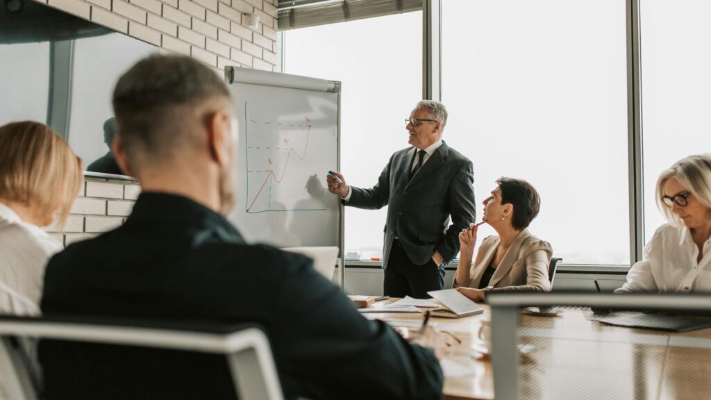 A sports manager leading a strategic session with a diverse team of professionals.