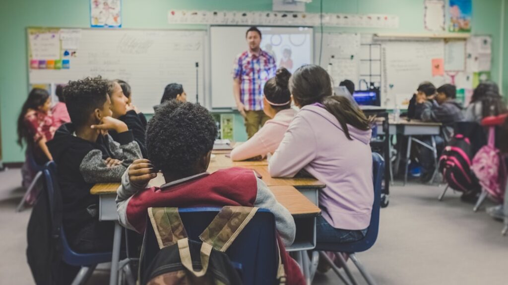 Students discussing sports management courses after 12th in a modern classroom