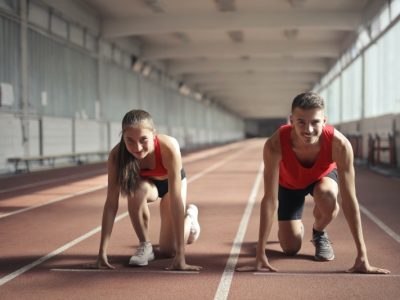 men-and-woman-in-red-tank-top-is-ready-to-run-on-track-field-3764538
